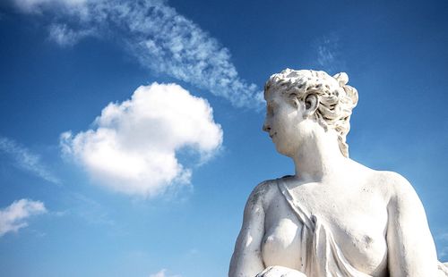Low angle view of statue against blue sky and clouds