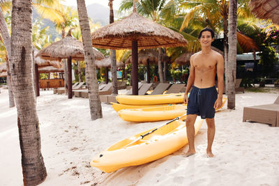 Rear view of man with umbrella while standing at beach