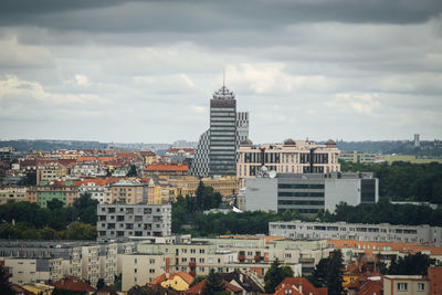 Buildings in city against cloudy sky