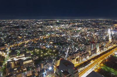 High angle view of city lit up at night