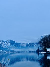 Scenic view of lake by snowcapped mountains against sky