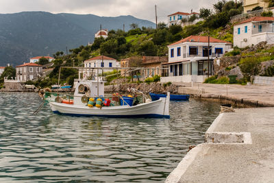 Sailboats in river by buildings in city