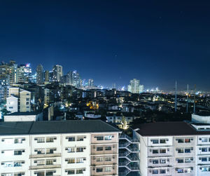 High angle view of illuminated buildings against clear blue sky