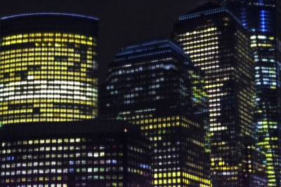 Low angle view of illuminated buildings against sky at night