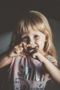 Portrait of cute girl making heart shape