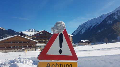 Information sign on snow covered field against sky