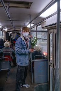 For safety reasons with a mask on his face, travels by public transport, in a public place