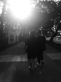 Rear view of women walking on street in city