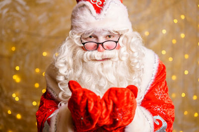 Funny man dressed as santa claus with big white beard on decorated background