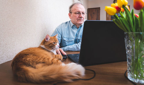 Man and cat on table