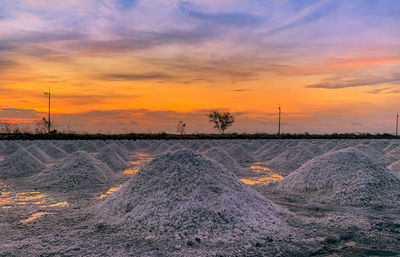 Scenic view of snowy field against sky during sunset