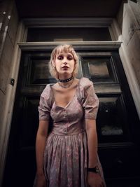 Portrait of beautiful young woman standing at home