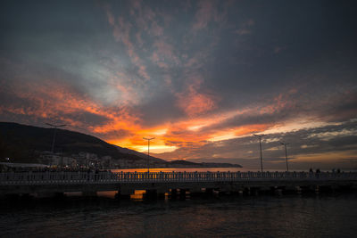 Bridge over river against sky during sunset