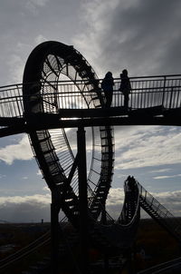 Low angle view of silhouette ferris wheel against sky