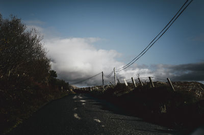 Road amidst trees against sky