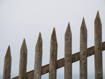 Low angle view of wooden fence against clear sky