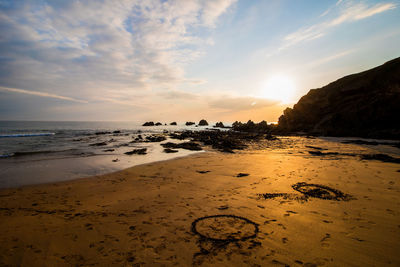 Scenic view of beach against sky during sunset