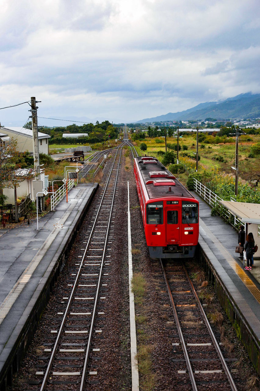 HIGH ANGLE VIEW OF TRAIN ON RAILROAD STATION AGAINST SKY