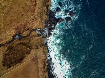 Aerial view of sea with rocky coastline
