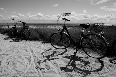 Bicycle on beach against sky