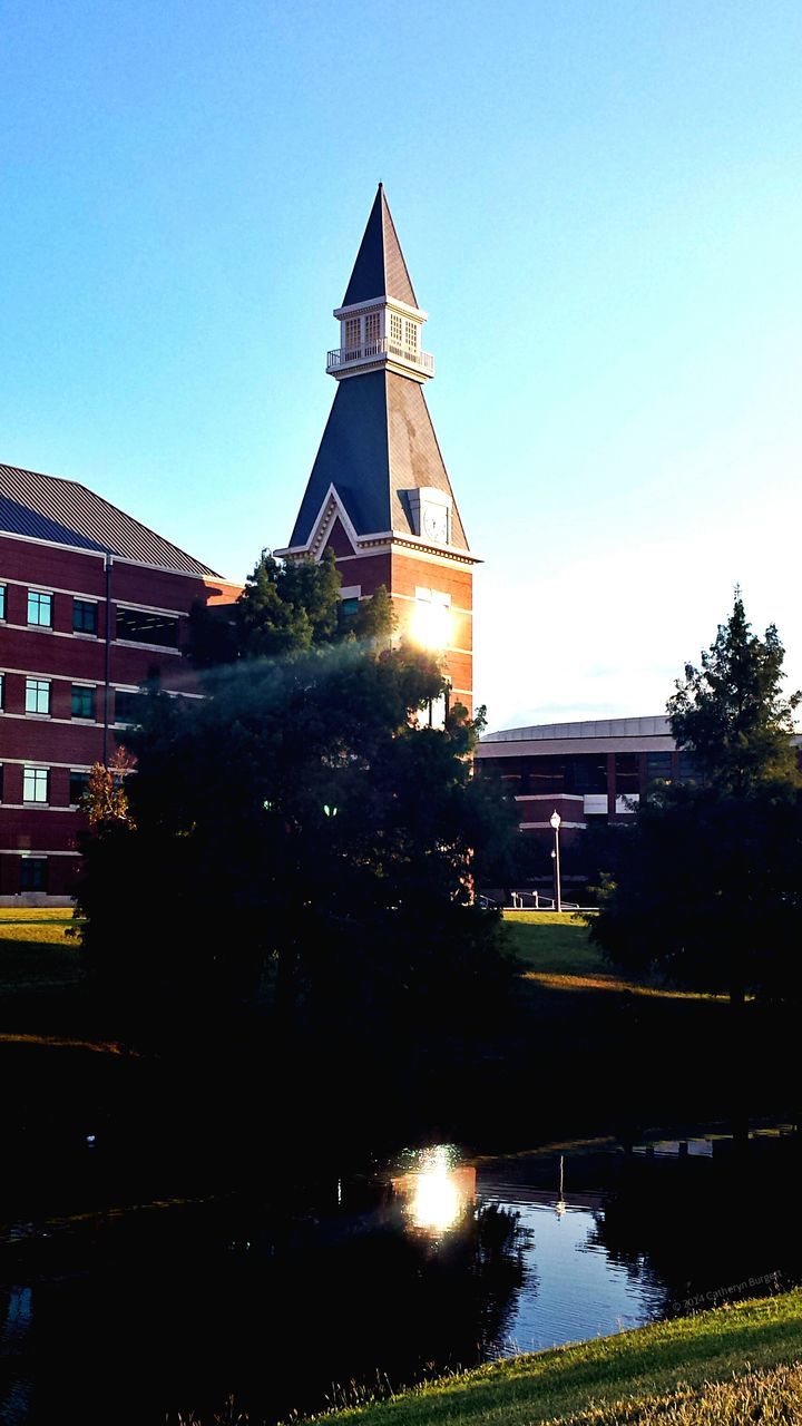 building exterior, architecture, built structure, clear sky, sun, sunlight, blue, tree, reflection, city, lens flare, sunbeam, low angle view, copy space, building, tower, sky, outdoors, growth, sunny