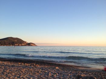 Scenic view of sea against clear sky during sunset