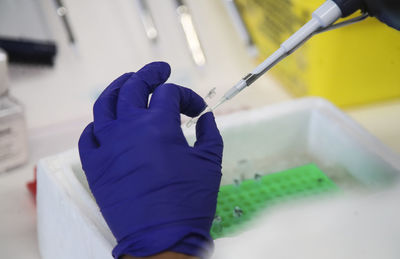 Cropped hand of scientist examining chemical in laboratory