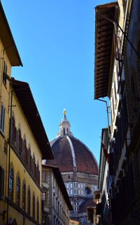 Low angle view of old buildings against clear blue sky