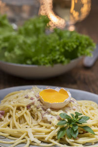 Close-up of spaghetti and egg yolk served in plate on table