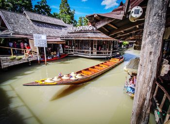 People in boat by river against buildings