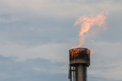 Smoke emitting from chimney against sky