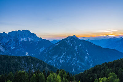 Scenic view of snowcapped mountains against sky during sunset