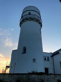 Low angle view of lighthouse against building