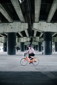 Man riding bicycle on bridge