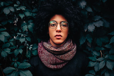 Portrait of young man amidst leaves in winter