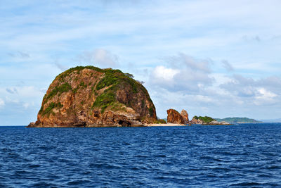 Rock formation in sea against sky