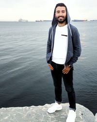 Portrait of young man standing by sea