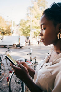 Woman looking at camera while using smart phone