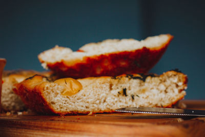 
homemade italian focaccia slices, with tomato and olive oil on a rustic wooden background.