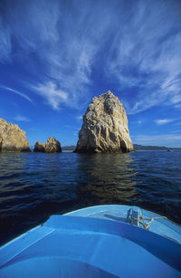 Rock formation in sea against blue sky