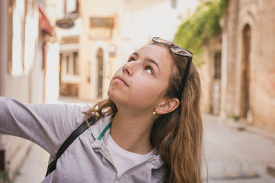 Close-up of girl looking up in city