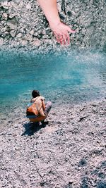 High angle view of woman sitting on sea shore