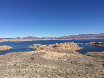 Scenic view of lake against clear blue sky