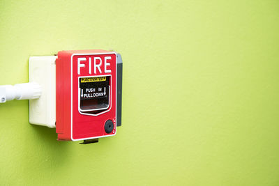 Close-up of fire alarm on green wall