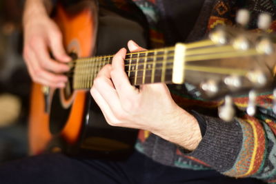 Playing acoustic guitar passionately close up photography