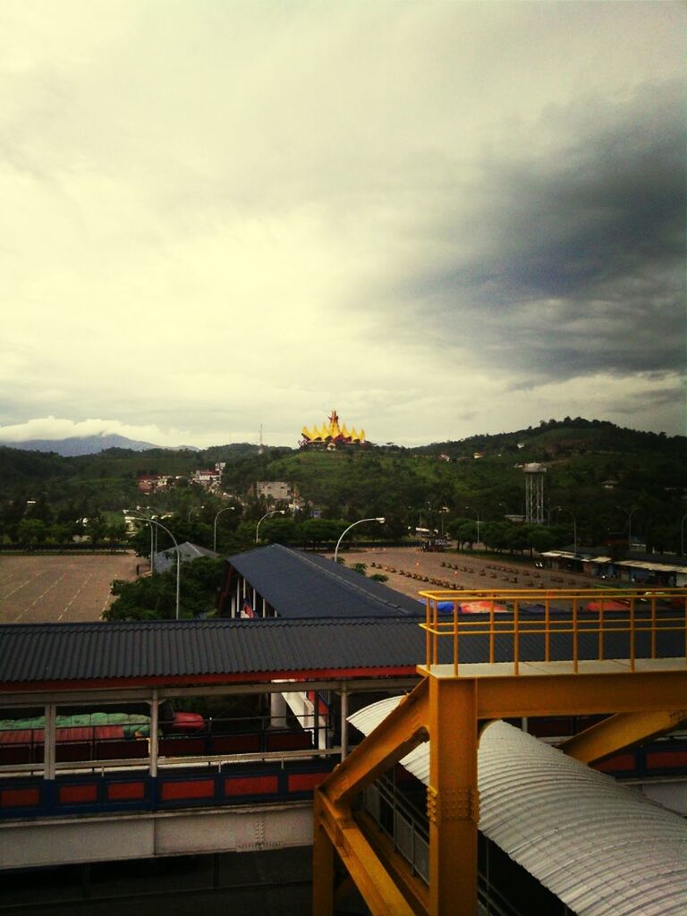 architecture, built structure, building exterior, sky, cloud - sky, railing, roof, cloudy, mountain, cloud, house, high angle view, city, cityscape, residential structure, residential building, weather, day, outdoors, residential district