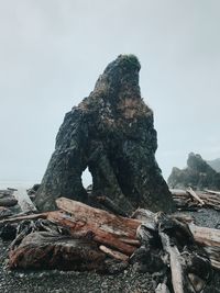 Stack of rock in sea against clear sky