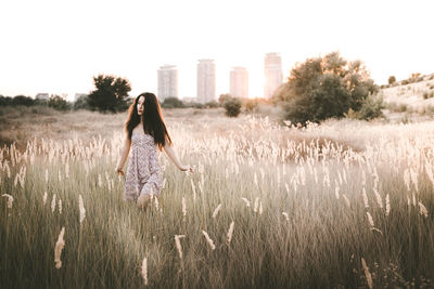 Woman standing on field against clear sky