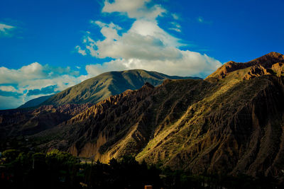 Scenic view of mountains against blue sky