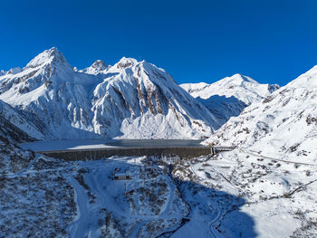 Scenic view of snowcapped mountains against clear blue sky